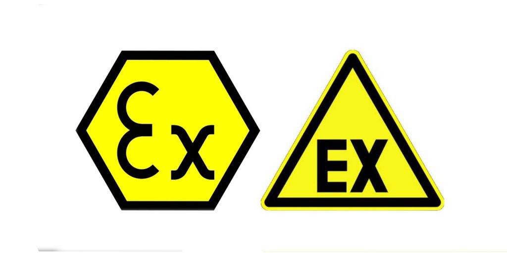 Technicians wearing safety gear inspect ATEX-certified powder handling equipment in an industrial facility.